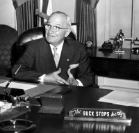 President Truman with his "The buck stops here" plaque on his desk.